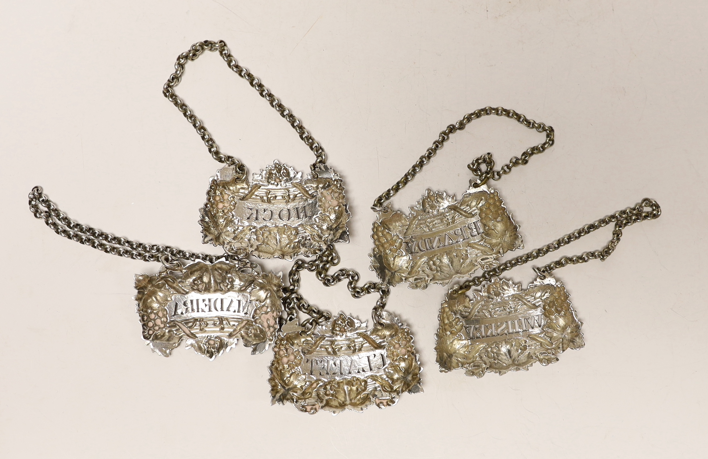 A matched set of five early 19th century ornate silver fruiting vine wine labels, Emes & Barnard, London, 1825/1827(2), Reily & Storer 1829 and 1850(2), width 6cm.